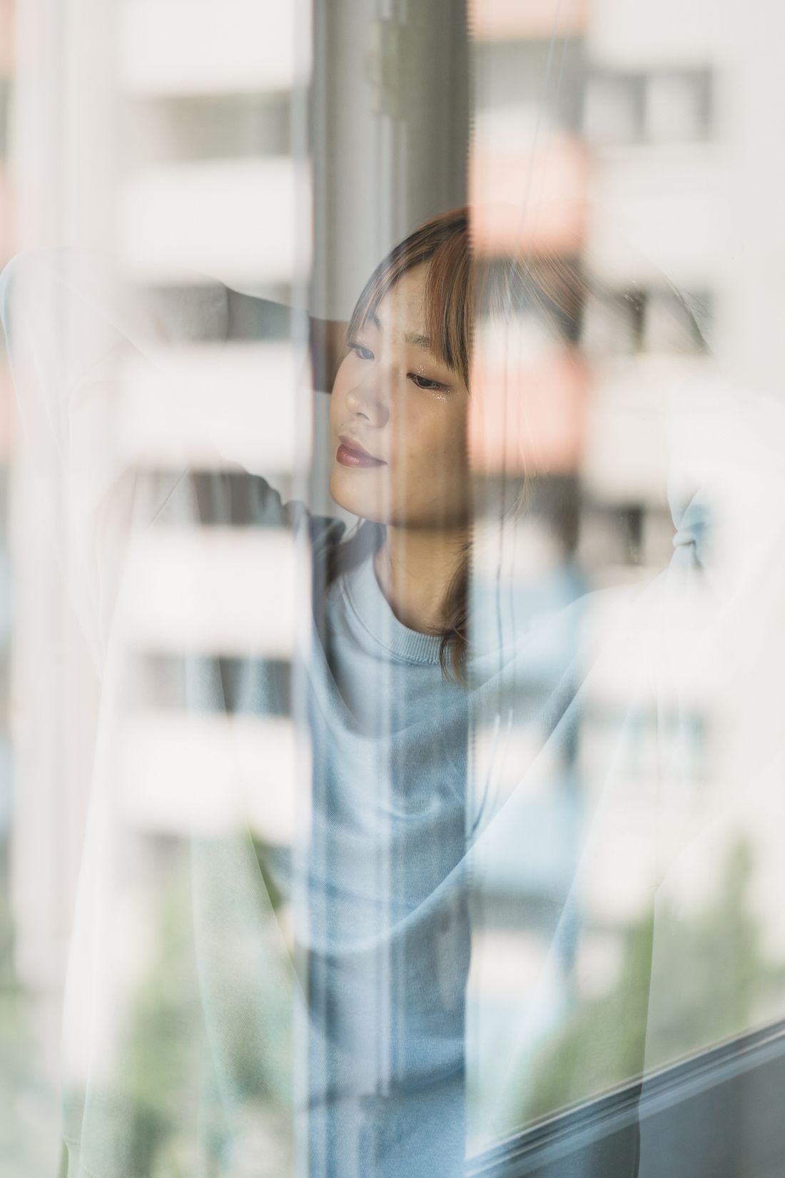 A person in quiet reflection by a window